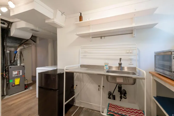 Utility sink with stainless steel basin and wall-mounted shelving