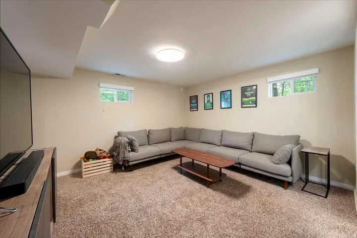 Carpeted living space featuring recessed lighting and multiple windows