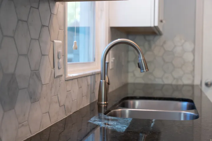 Dual-basin stainless steel sink with a gooseneck faucet