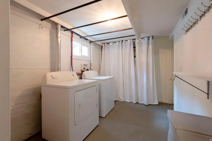 Laundry area with a window, exposed piping, and a built-in shelf