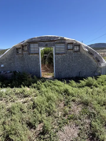 Greenhouse structure with multiple windows and a central doorway