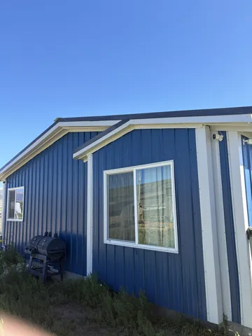 Blue corrugated metal siding with white trim