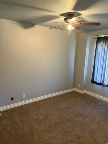 Neutral paint palette with carpet flooring, a ceiling fan with integrated lighting, and white baseboards