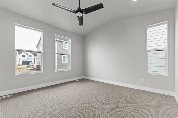 Vaulted ceiling with a black ceiling fan, recessed lighting, carpet flooring, and multiple windows