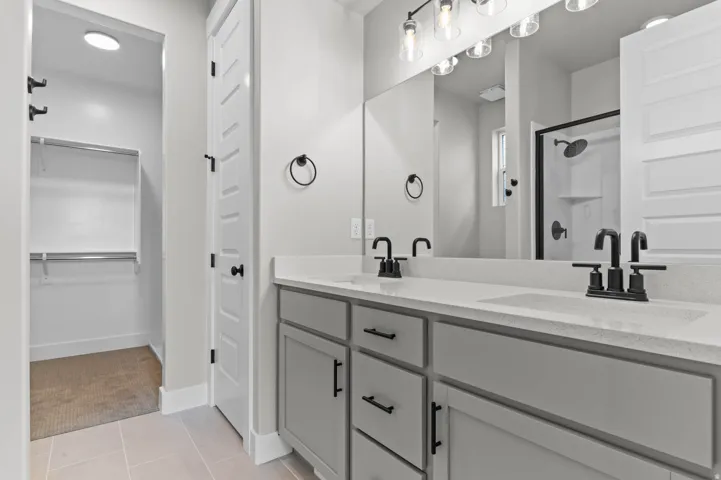 Dual vanity with integrated sinks, light gray cabinetry, and matte black fixtures