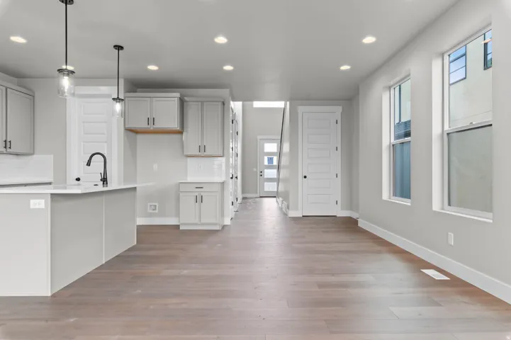 Open concept living area featuring wood-finish flooring, recessed lighting, and large windows