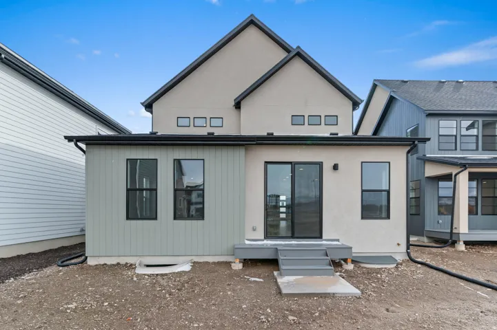 Stucco exterior with vertical panel siding, black-framed windows, and a sliding glass door