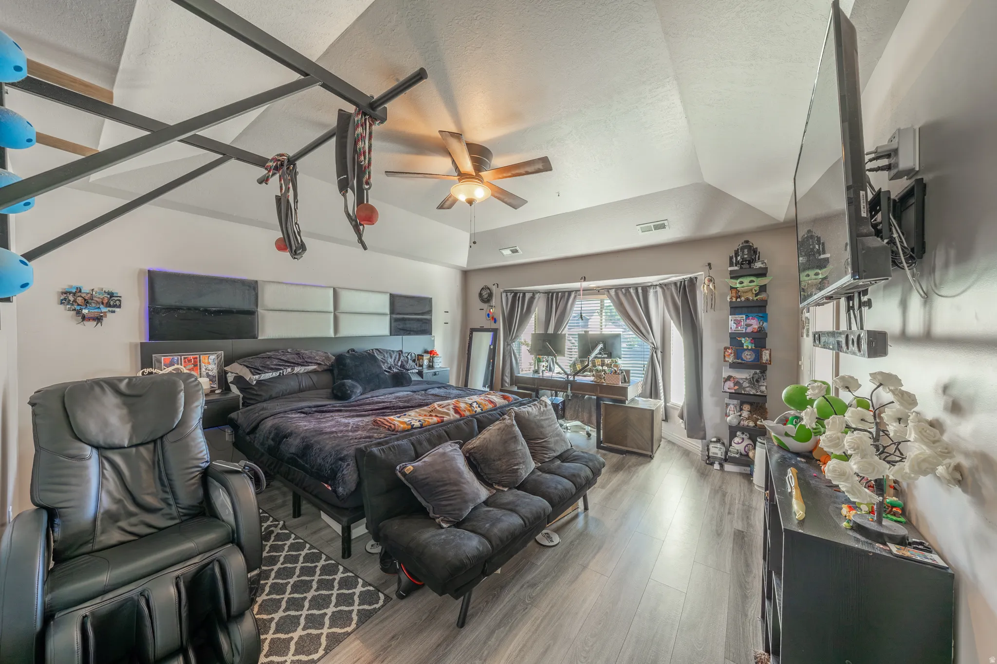 Spacious primary suite showcasing a dramatic vaulted ceiling, abundant natural light, and contemporary flooring, complete with a private en-suite bathroom featuring a relaxing jetted tub, expansive vanity, and generous walk-in closet
