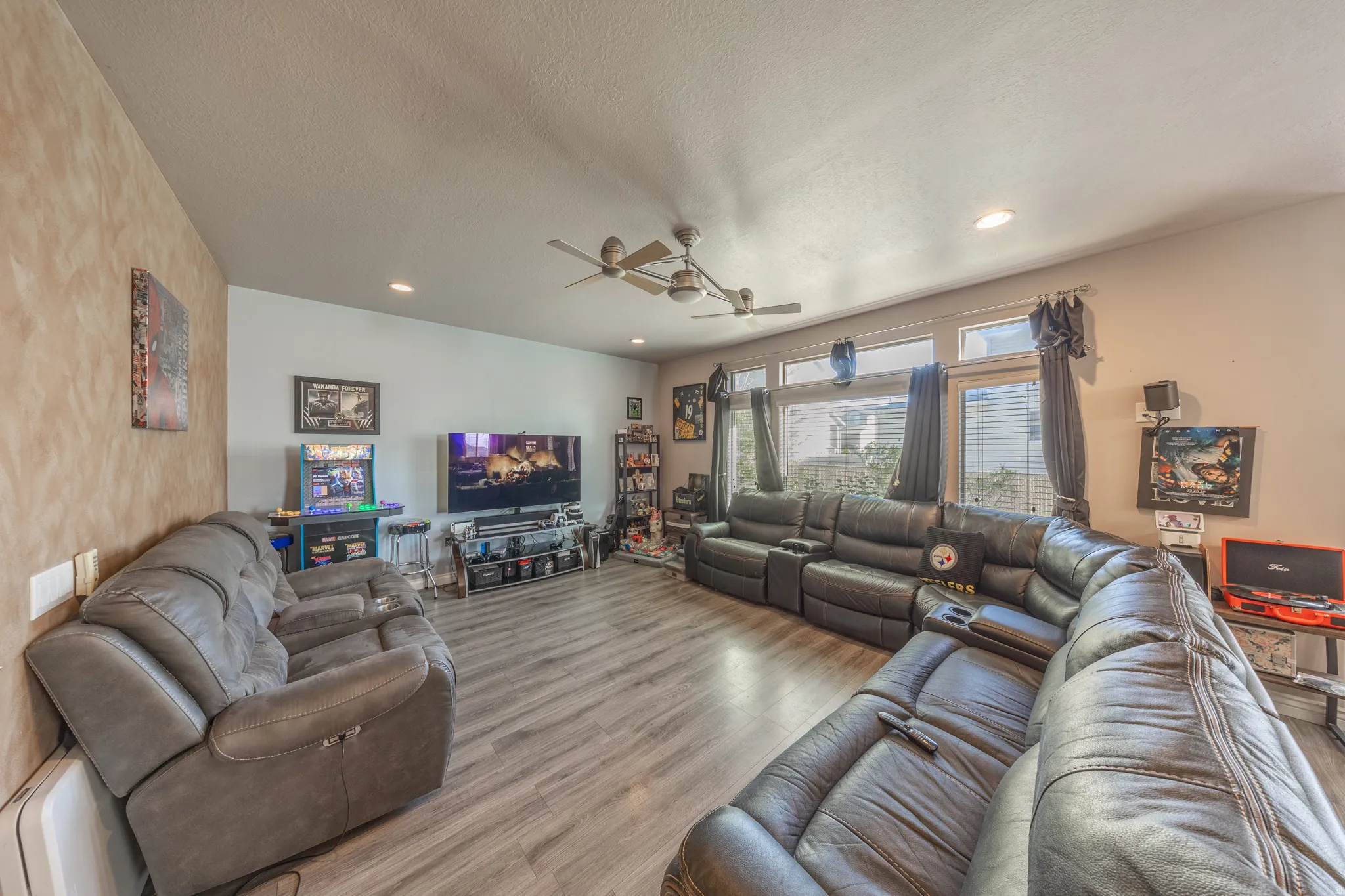Expansive great room featuring abundant natural light, stylish flooring, recessed lighting, and generous space for comfortable everyday living and effortless entertaining.