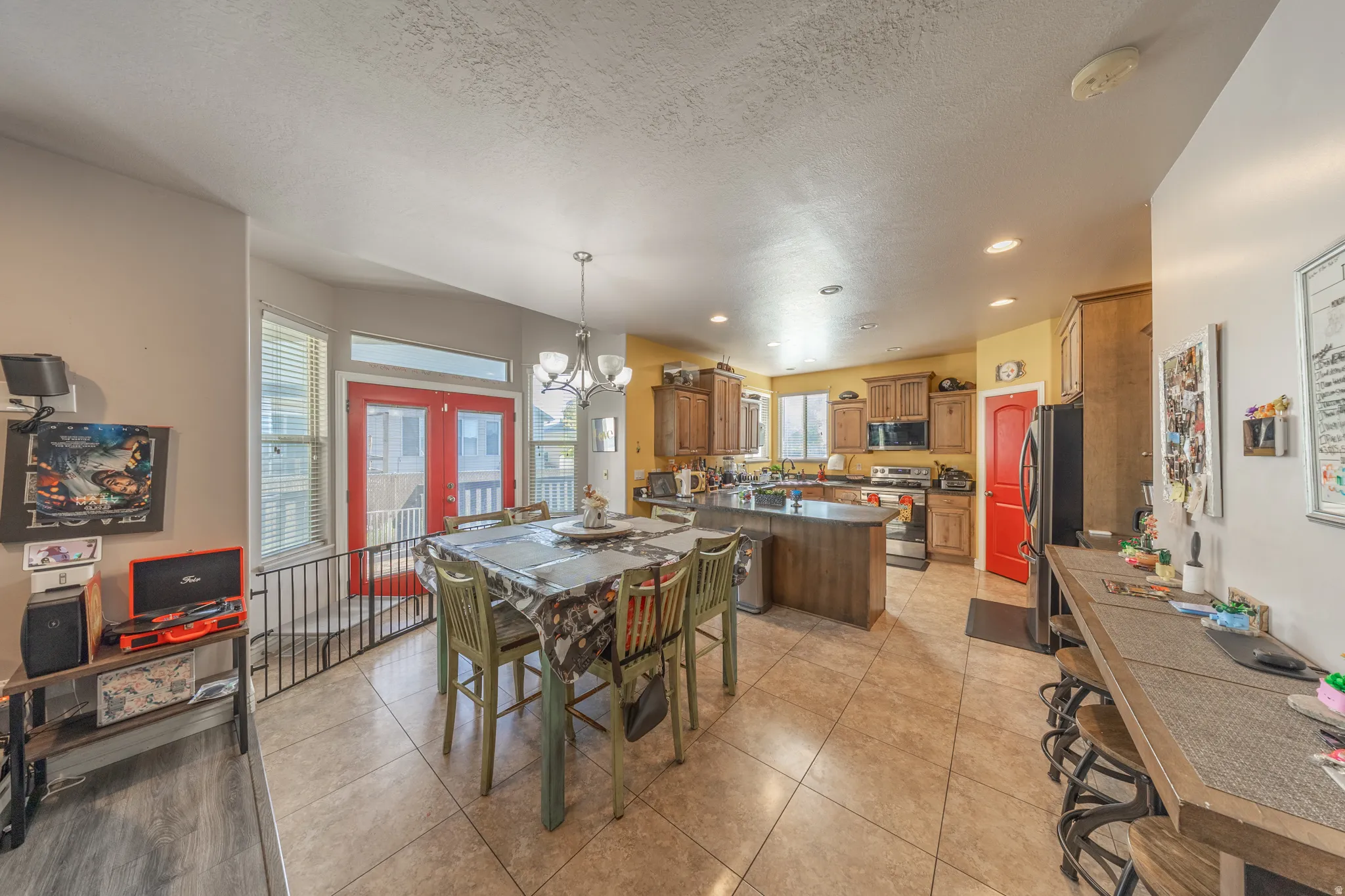 Inviting open-concept kitchen and dining area featuring abundant natural light, generous cabinetry, a spacious center island, recessed lighting, and direct access to the covered deck—ideal for everyday living and entertaining.