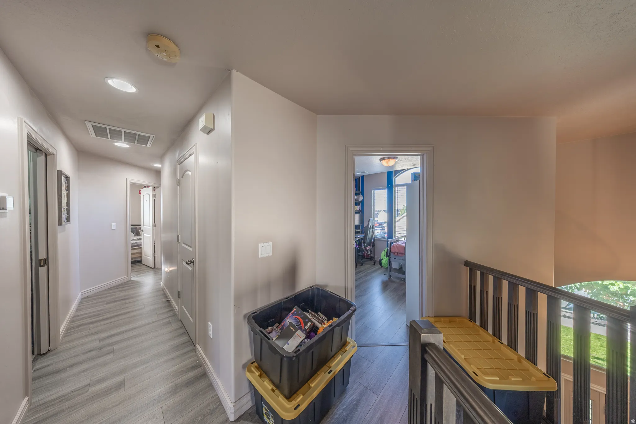 Bright upper-level landing featuring contemporary flooring, recessed lighting, and an open design that provides convenient access to the surrounding bedrooms and bathrooms.
