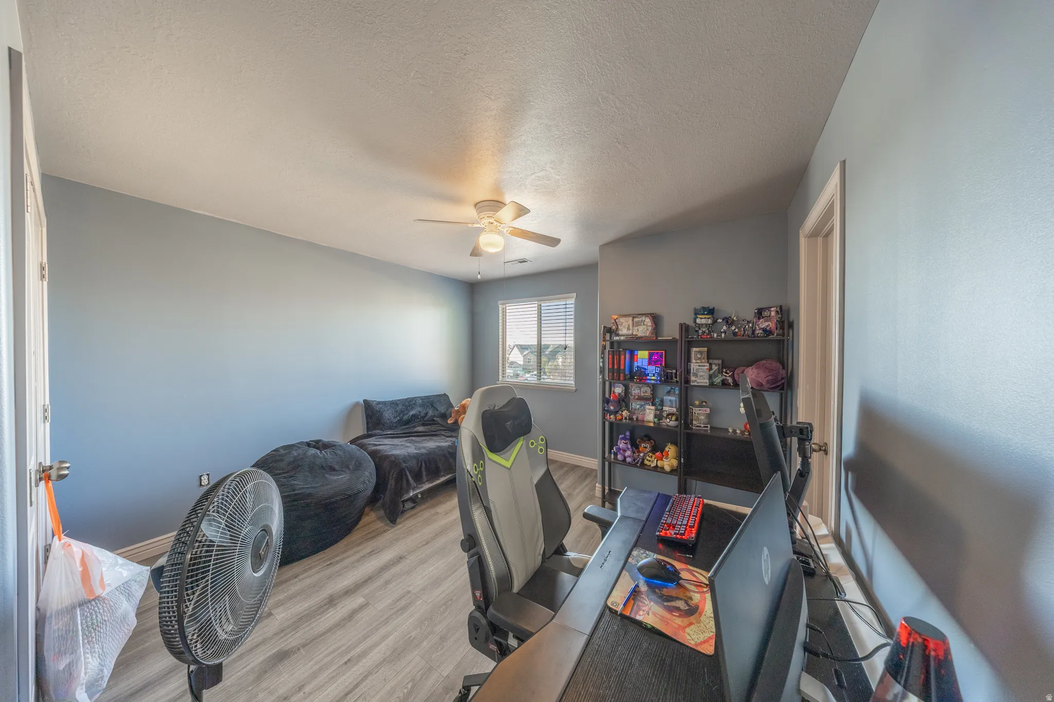 Spacious second-floor bedroom featuring stylish flooring, abundant natural light, a ceiling fan, and convenient direct access to the shared Jack-and-Jill bathroom.