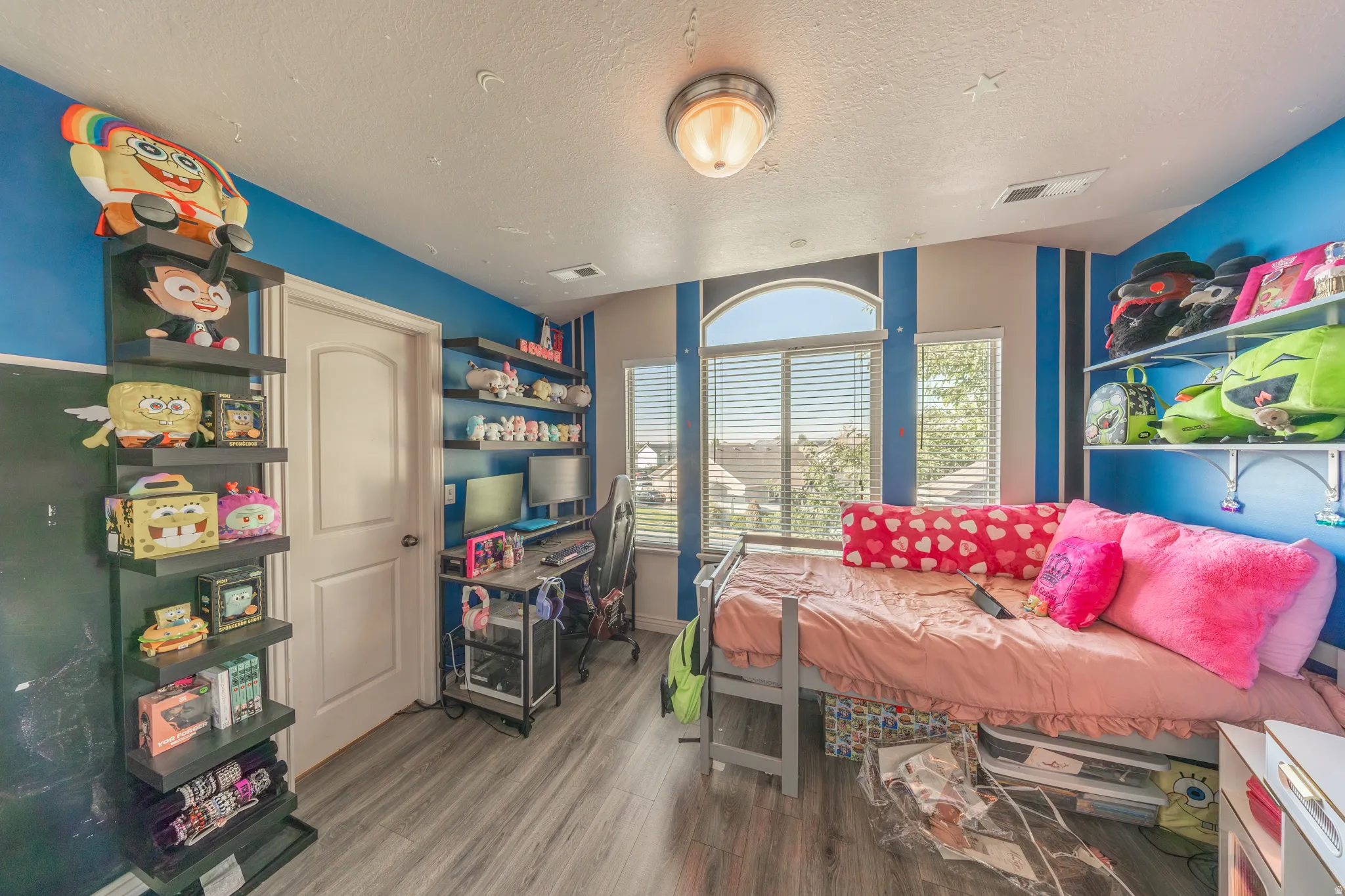Bright second-floor bedroom featuring stylish flooring, abundant natural light, generous closet space, and convenient direct access to a shared Jack-and-Jill bathroom.