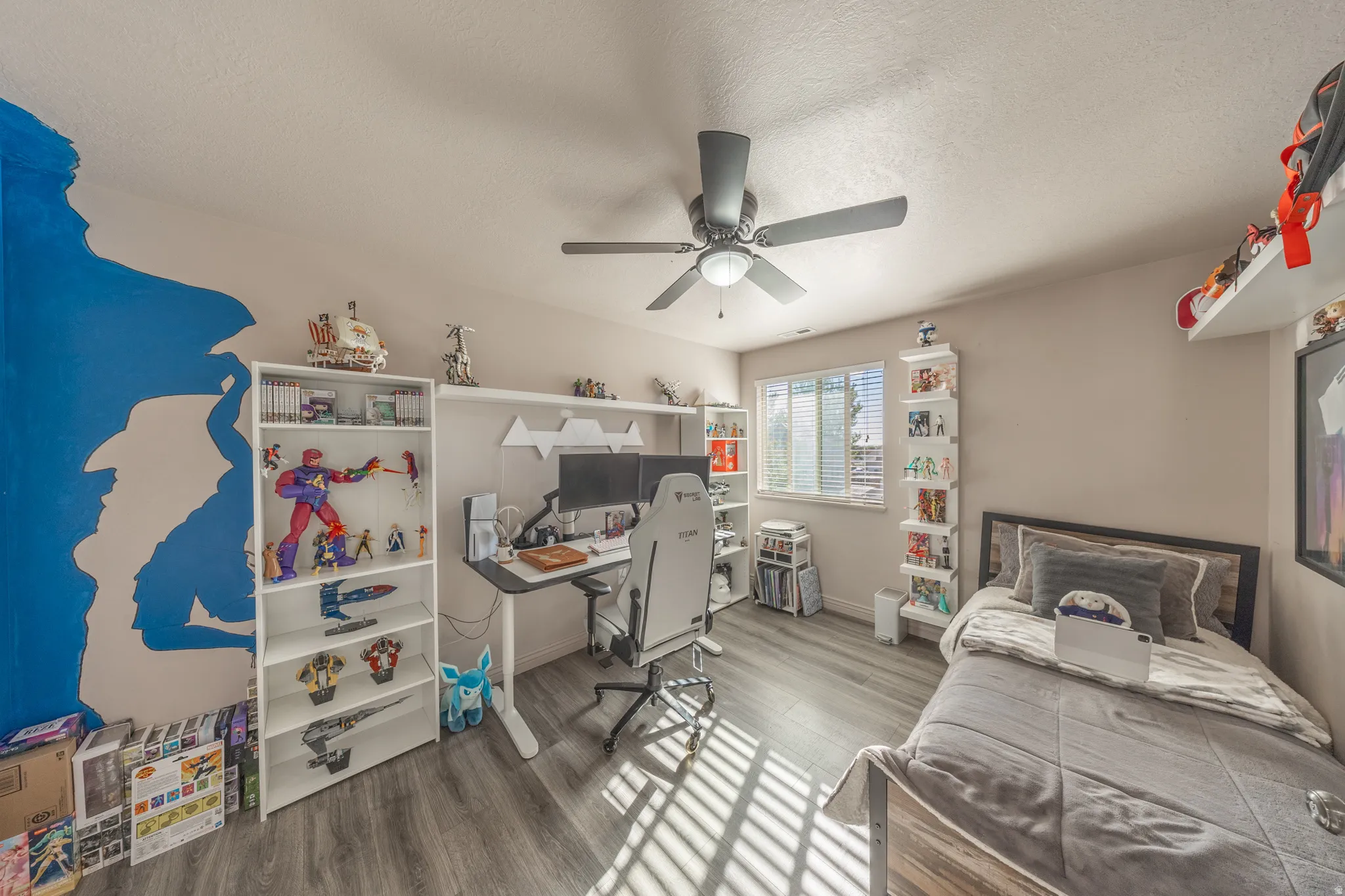 Spacious third bedroom featuring contemporary flooring, abundant natural light, a ceiling fan, and ample room for a comfortable study or workspace.