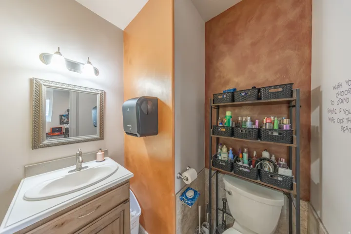 Conveniently located main-level half bath featuring a stylish vanity and warm decorative finishes.