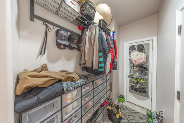 Convenient mudroom located just off the kitchen and adjacent to the garage entry, providing a practical drop zone with plenty of space for organized storage.