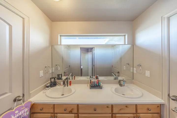 Thoughtfully designed Jack-and-Jill bathroom connecting two second-floor bedrooms, featuring dual vanities, a private toilet area, and a shared tub-and-shower combination for added comfort and convenience.
