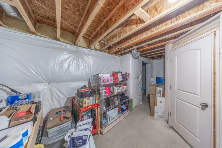 Additional unfinished basement space featuring completed framing and insulation, abundant storage, and a flexible layout ready to be customized to suit the next owner’s needs.