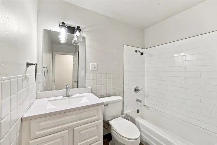 Bathroom featuring a white vanity with an integrated sink, polished chrome faucet, and quartz countertop