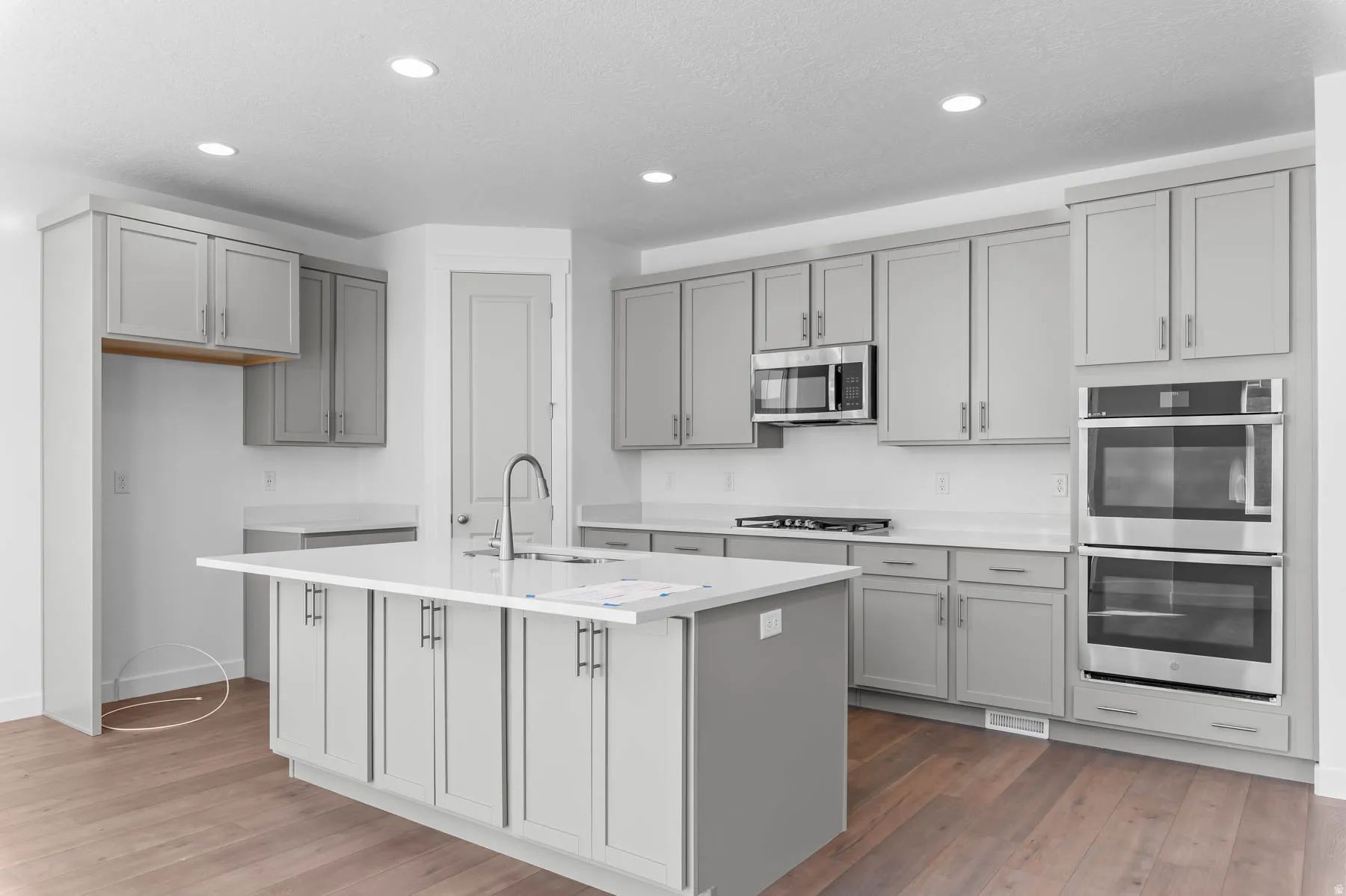 Expansive kitchen island with an undermount sink and gooseneck faucet