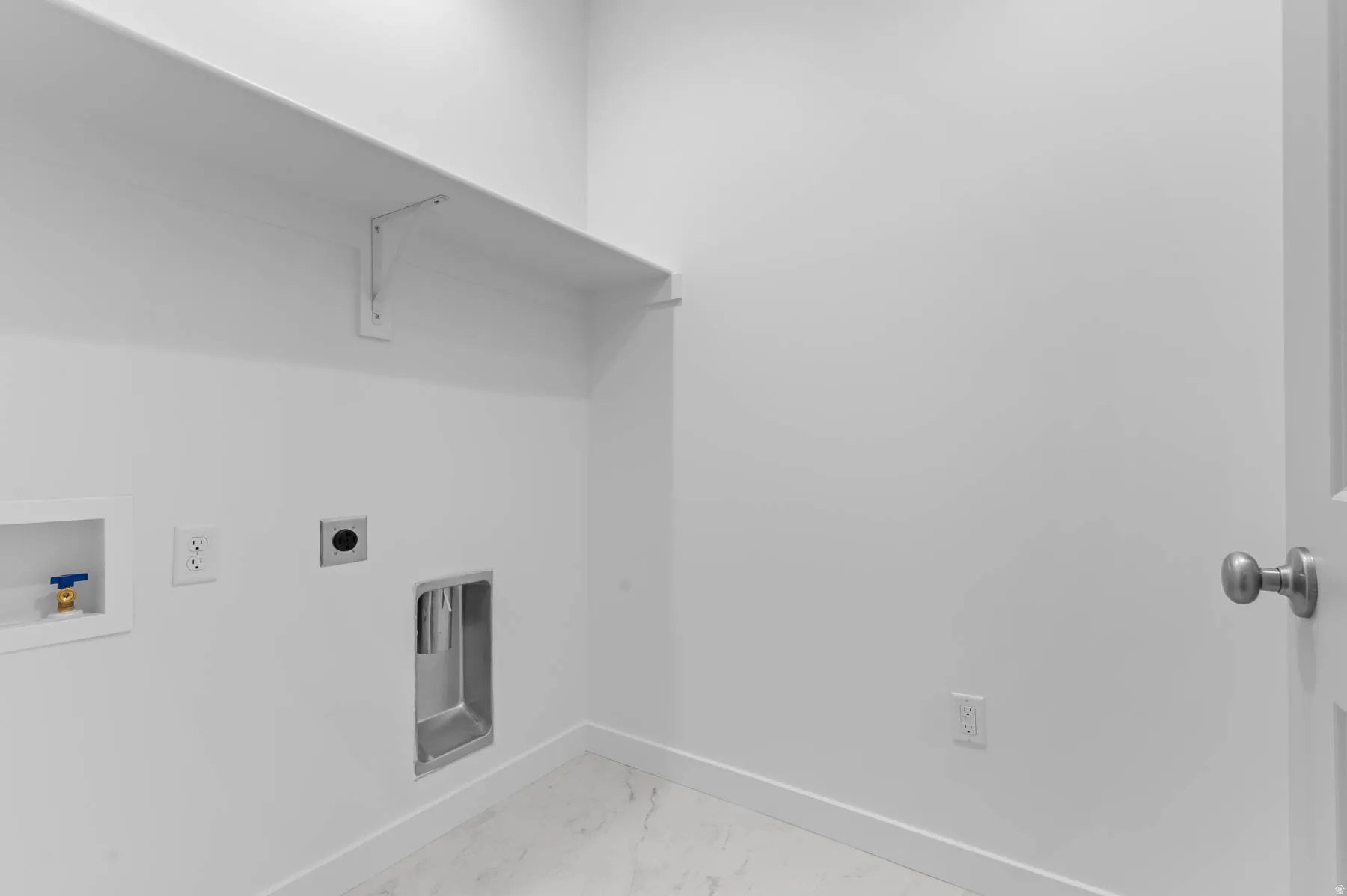 Laundry area featuring white walls, a built-in shelf, and a utility sink hookup