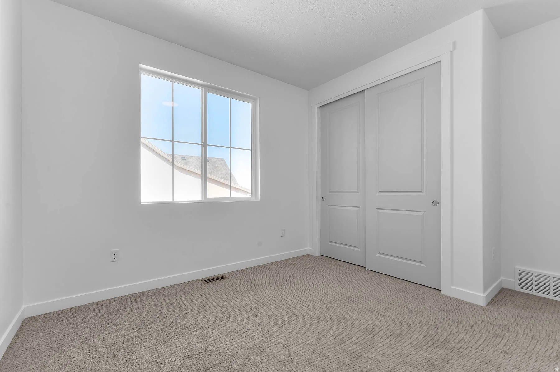 Bright interior with neutral carpet, white walls, and a large window