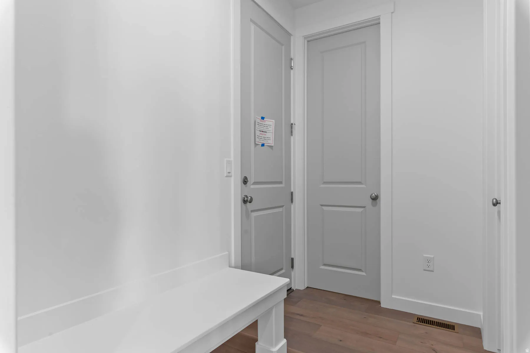 Wood-finish flooring with white walls and trim