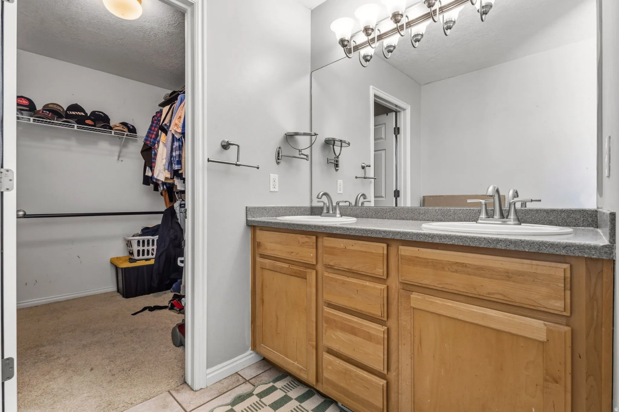 Dual vanity with wood-finish cabinetry, integrated sinks, and polished chrome fixtures