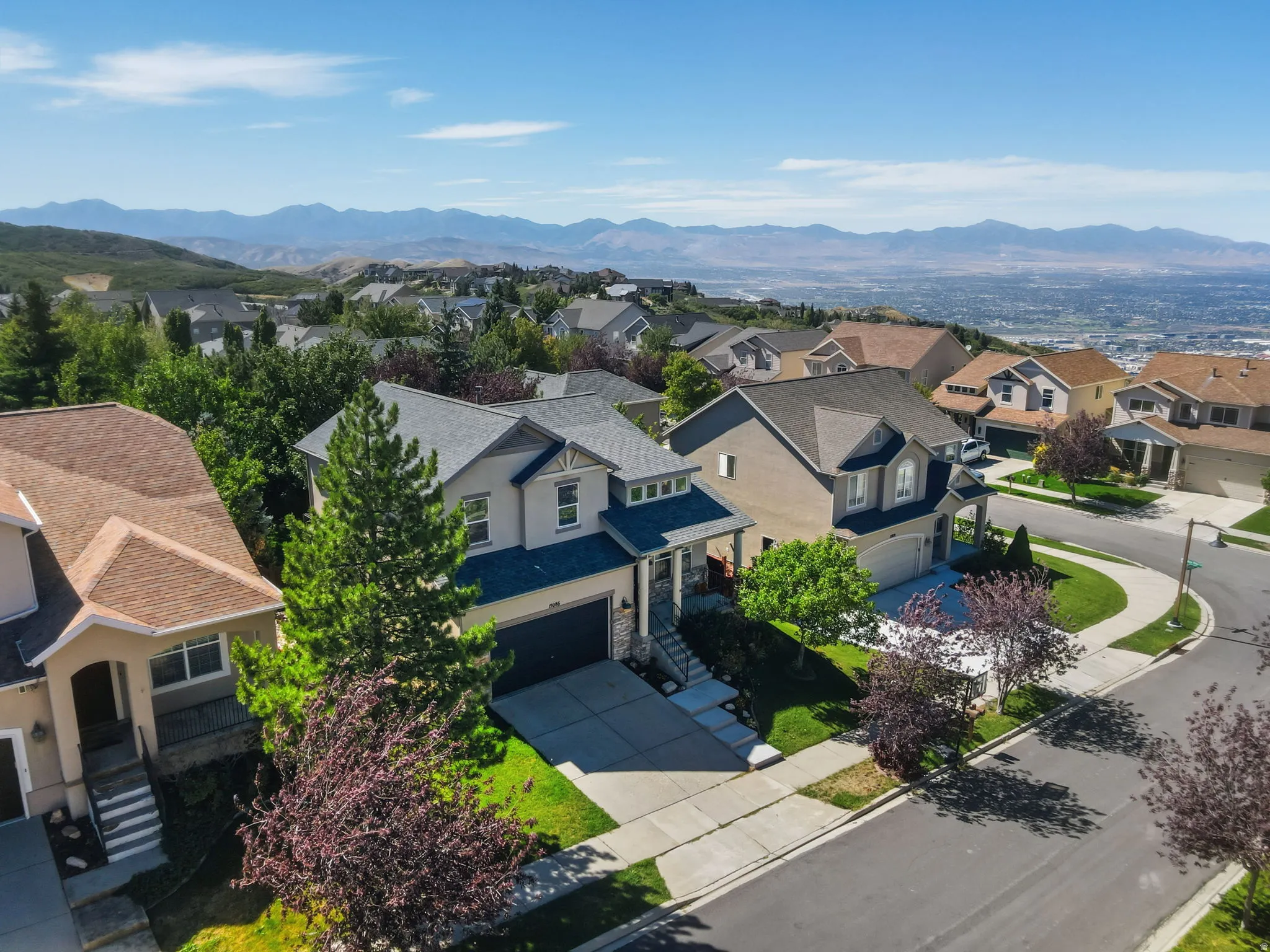 Two-story residence with an attached garage, featuring a neutral exterior color palette and a dark roof