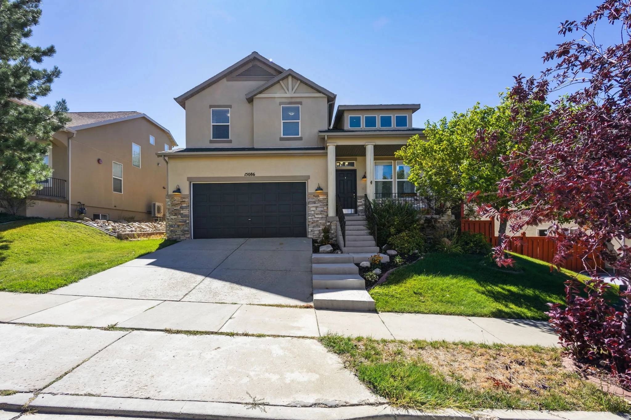 Stucco exterior with stone accenting and a covered front porch