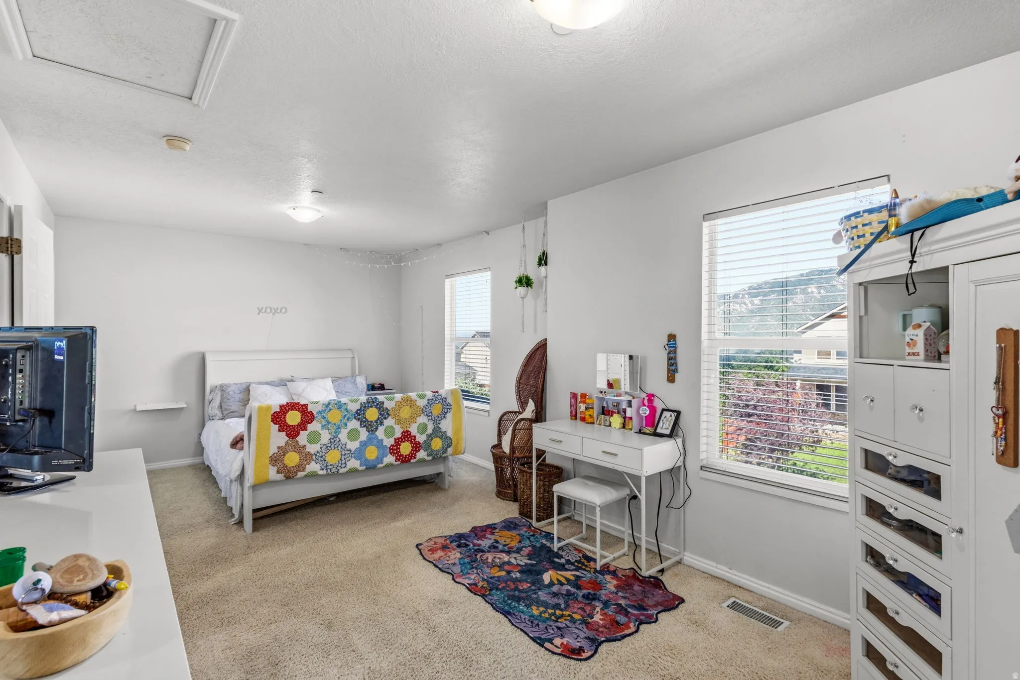 Carpeted flooring, white walls, two windows with blinds, recessed lighting, and a ceiling access panel
