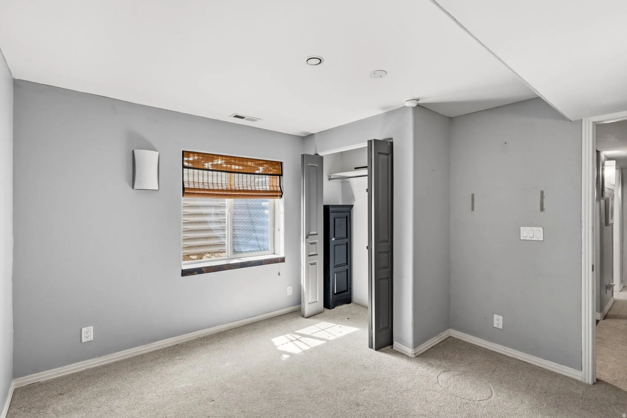 Recessed lighting, wall sconce, and carpeted flooring