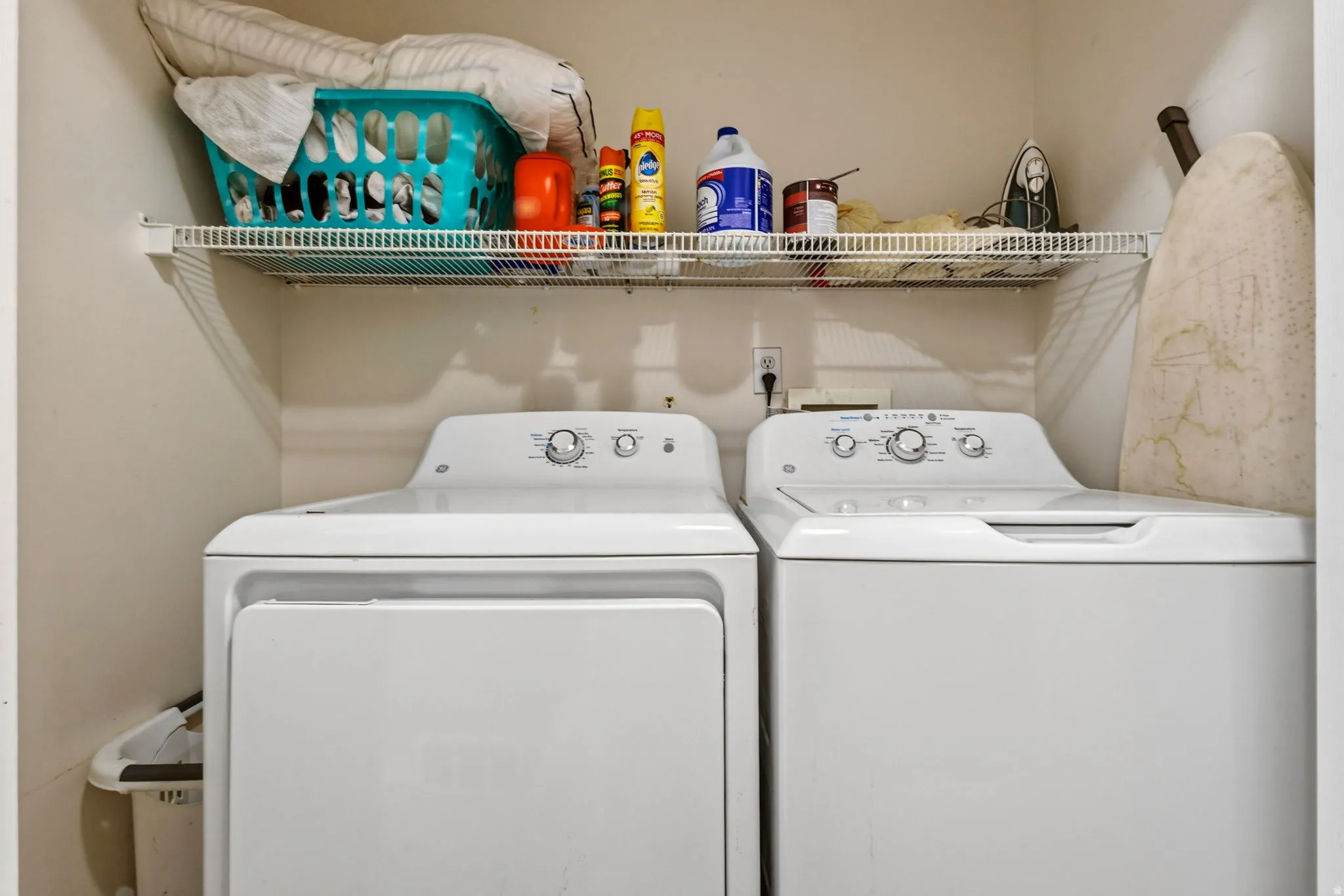 Laundry area featuring a side-by-side washer and dryer, along with a wire storage shelf