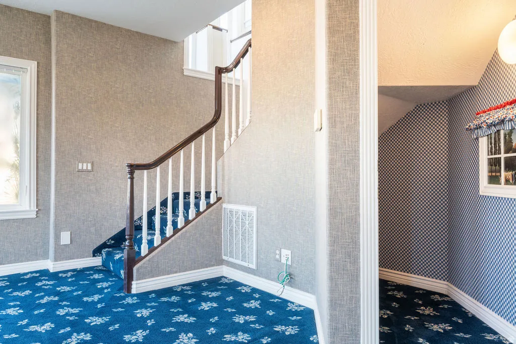 Curved staircase with wood handrail and white balusters
