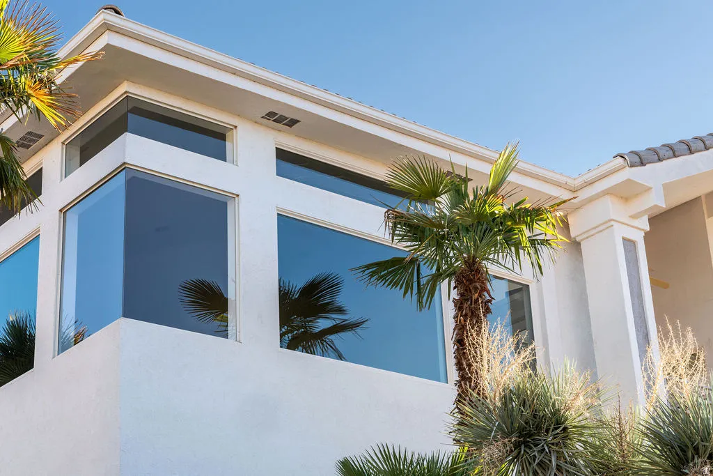 Stucco exterior featuring multiple large windows and a corner window