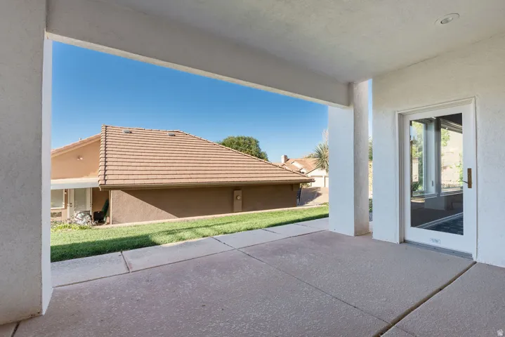 Covered patio with concrete flooring and a glass-paneled door