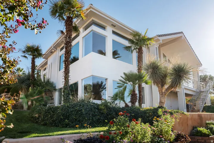 Modern architecture featuring a white exterior, multiple large windows, a tiled roof, and an exterior staircase