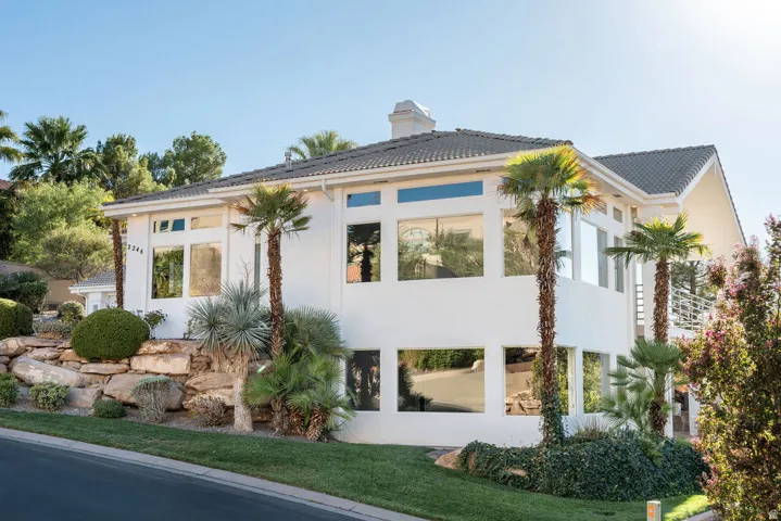 Modern exterior featuring a white stucco finish, a tile roof, and extensive large format windows