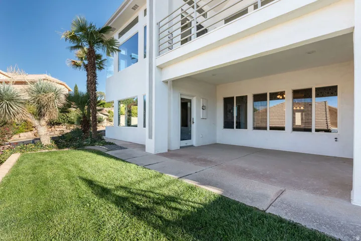 Manicured lawn with a concrete patio, covered outdoor area, and established landscaping