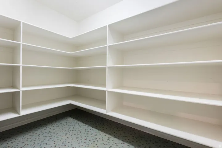 Extensive built-in shelving with multiple levels, clean white finishes, and durable flooring