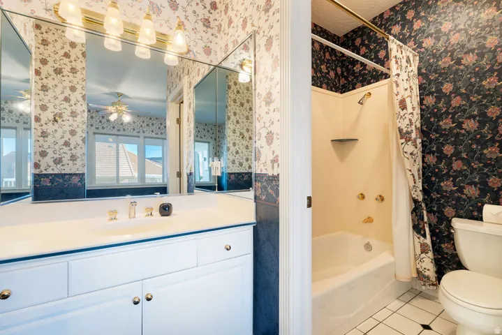 White vanity with gold-tone hardware, integrated sink, and mirrored wall