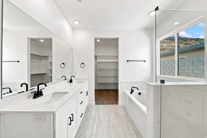 Double vanity with white cabinetry, matte black fixtures, and a large integrated mirror