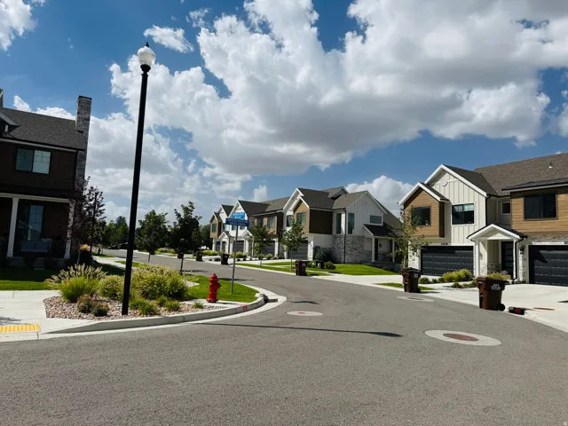 Streetscape featuring modern townhomes with mixed-material facades and attached garages