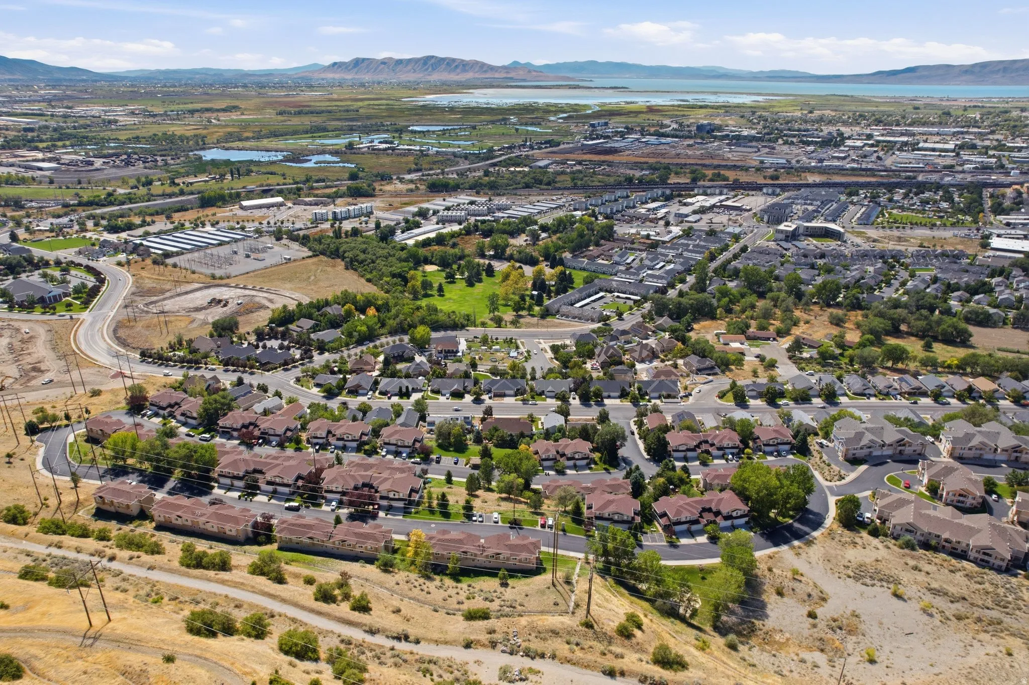 Extensive neighborhood with residential properties, green spaces, and a distant body of water