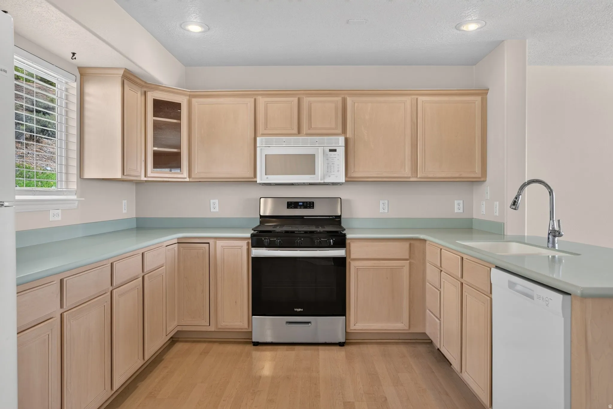 U-shaped kitchen with light wood-finish cabinetry