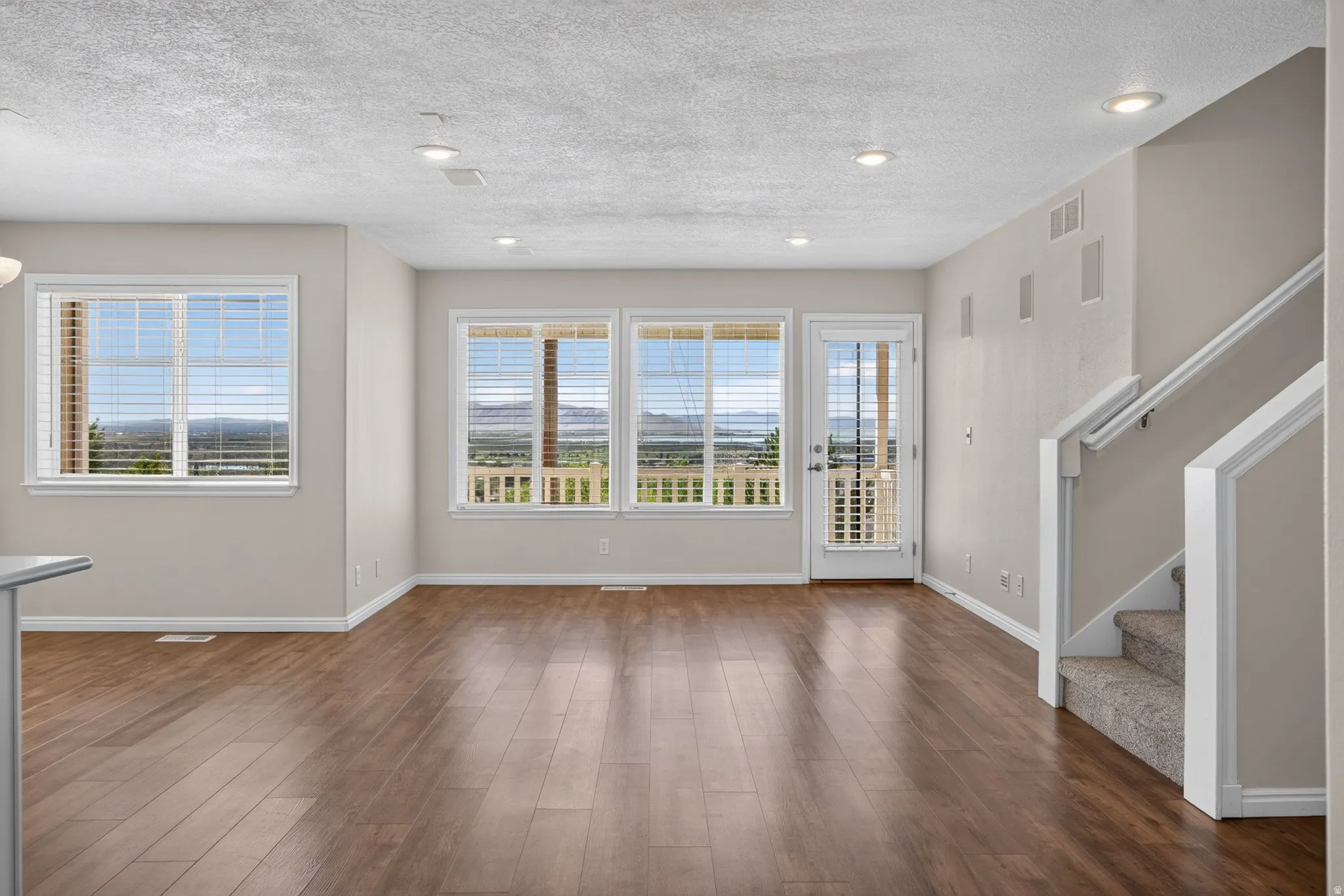 Wood-finish flooring, recessed lighting, and a white framed glass-paneled door