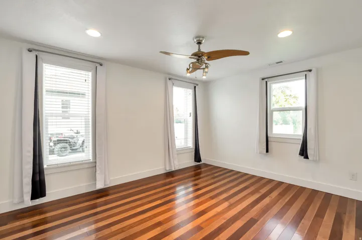 Wood-finish flooring, recessed lighting, ceiling fan light fixture, and multiple windows