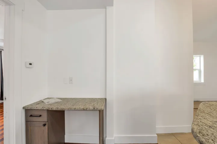 Built-in desk featuring a stone-finish countertop and wood-finish cabinetry