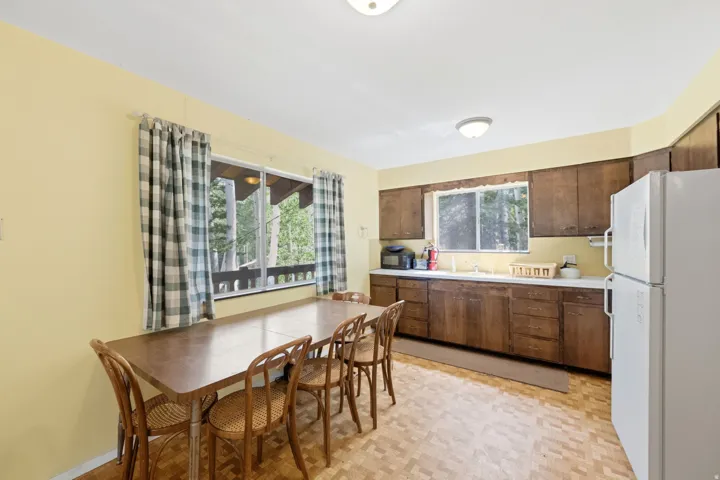 Kitchen featuring wood-finish cabinetry, a large window, a built-in sink, and integrated appliances