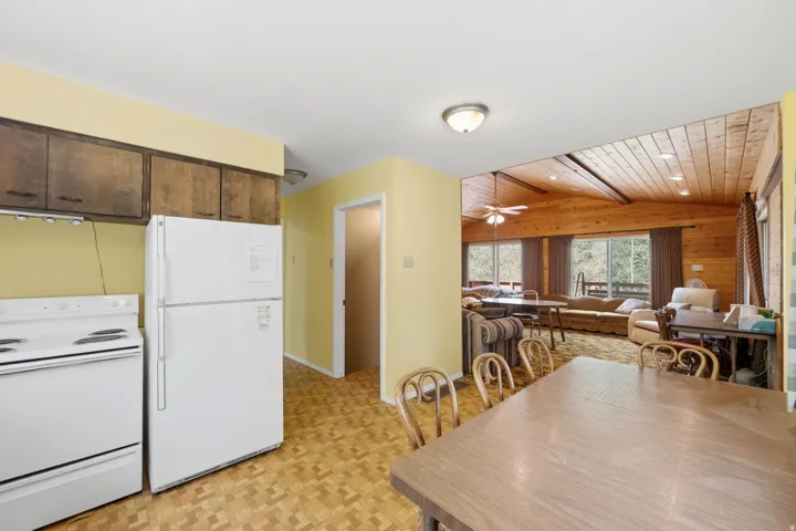 Kitchen area with wood-finish flooring, wood cabinetry, and white appliances